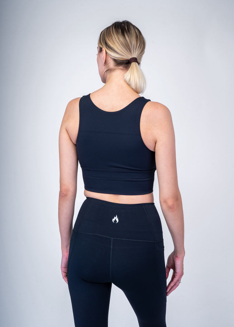 A woman wearing a black athletic outfit with a Spofire  logo on a plain background