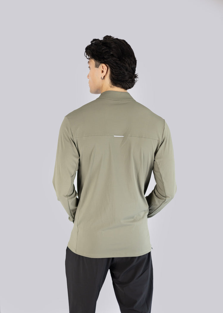 A man wearing an olive long-sleeve Jacket on a gray background